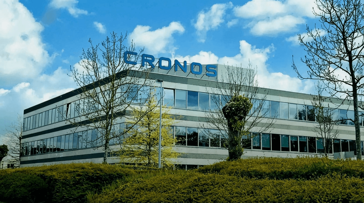 Cronos offices, outside picture taken from behind some trees, probably in spring season